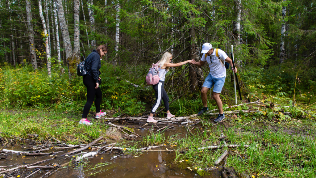 девушка переходит лужу по бревну