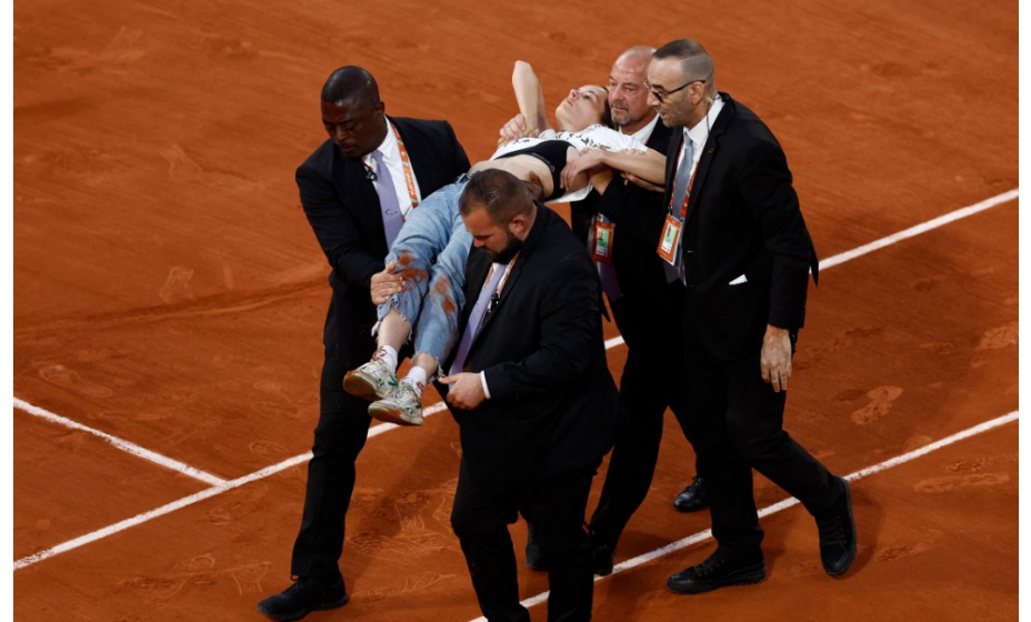 Девушка выбежала на корт во Франции и приковала себя к сетке. 
Фото: Reuters