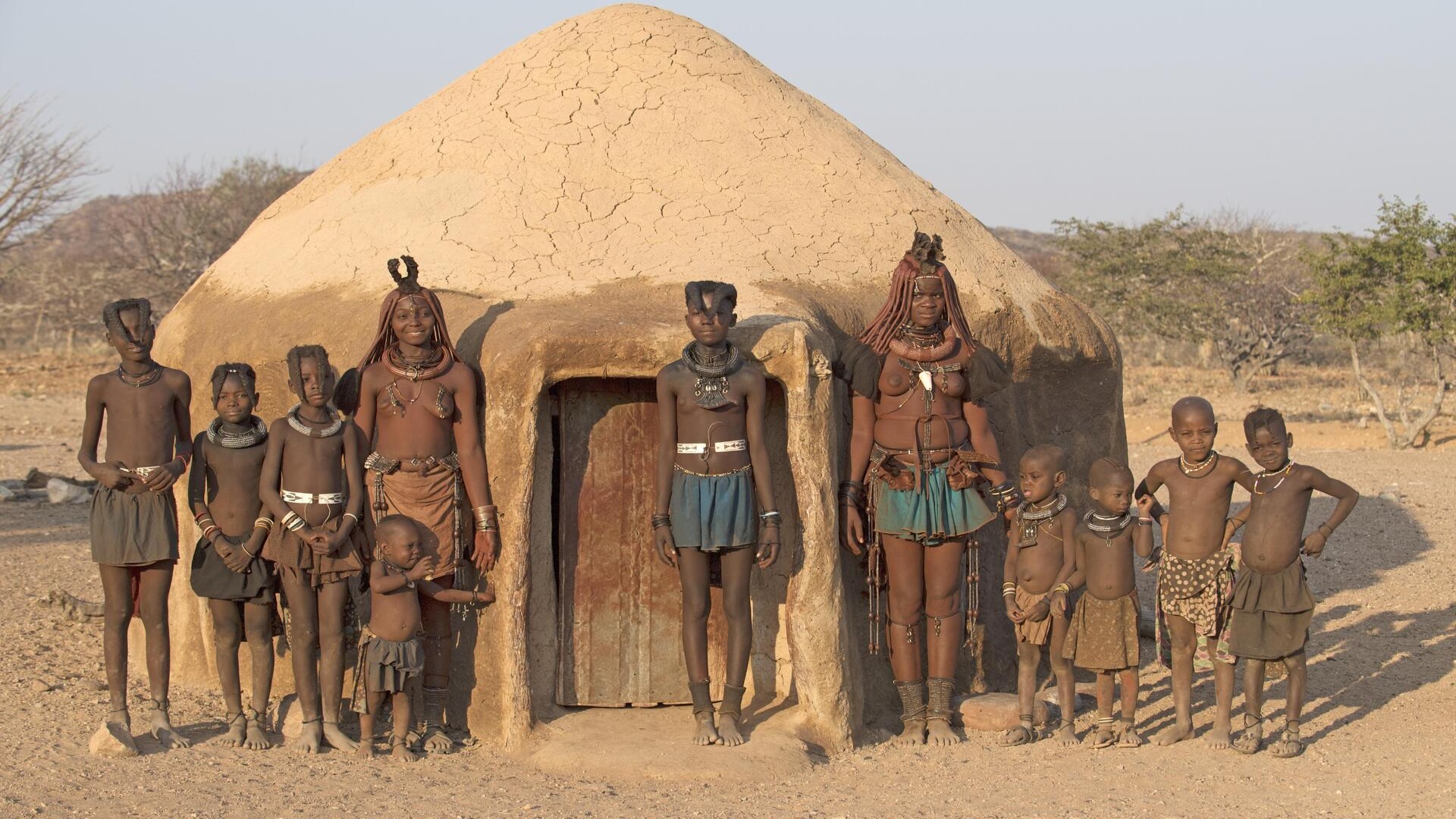 Женщины племени Химба с детьми перед хижиной, Намибия.