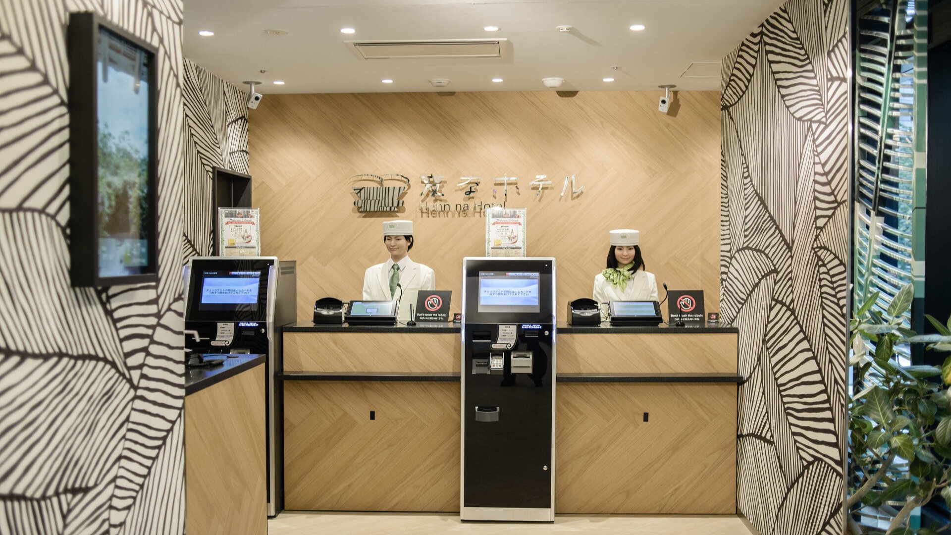 Роботы на стойке регистрации в отеле Henn na Hotel, Токио.